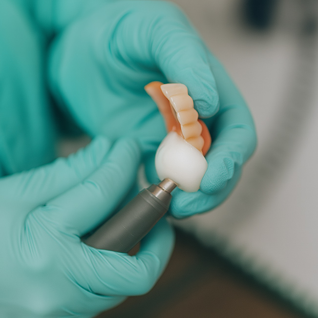 Gründliche Reinigung einer Zahnprothese mit einem Polierhandstück bei Lotus Dent in Ingolstadt